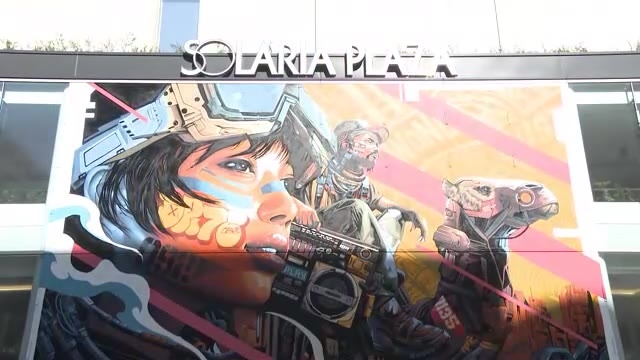 巨大壁画アートが福岡市・天神に登場　アーティストのDRAGON76さん手がける　「自らを高める経験を求める旅人」を表現　ガラス一面に描く